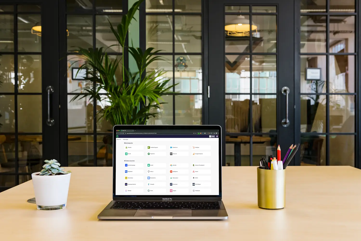 Geckoboard integration picker showing all available data sources on a laptop