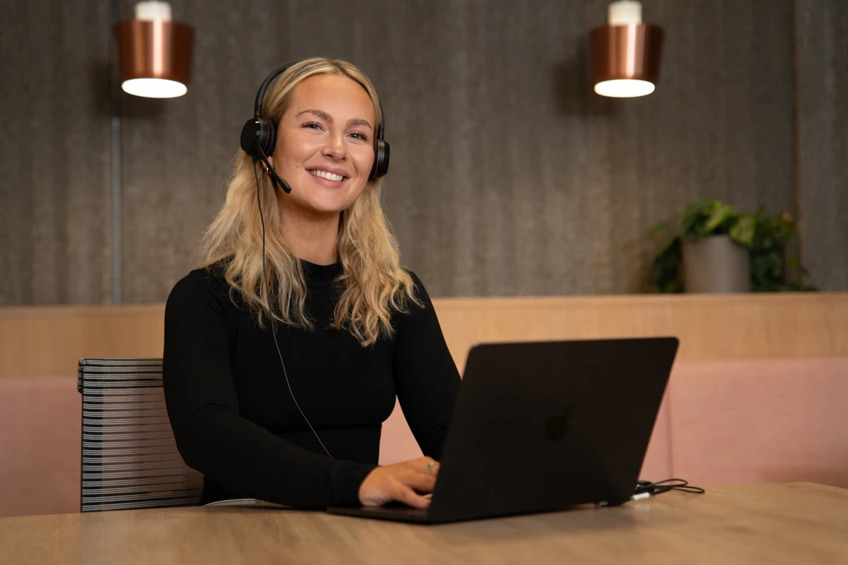 Sonya from the Geckoboard team, wearing a headset and smiling on a call