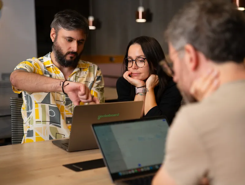 A team reviewing a Geckoboard dashboard together on laptops