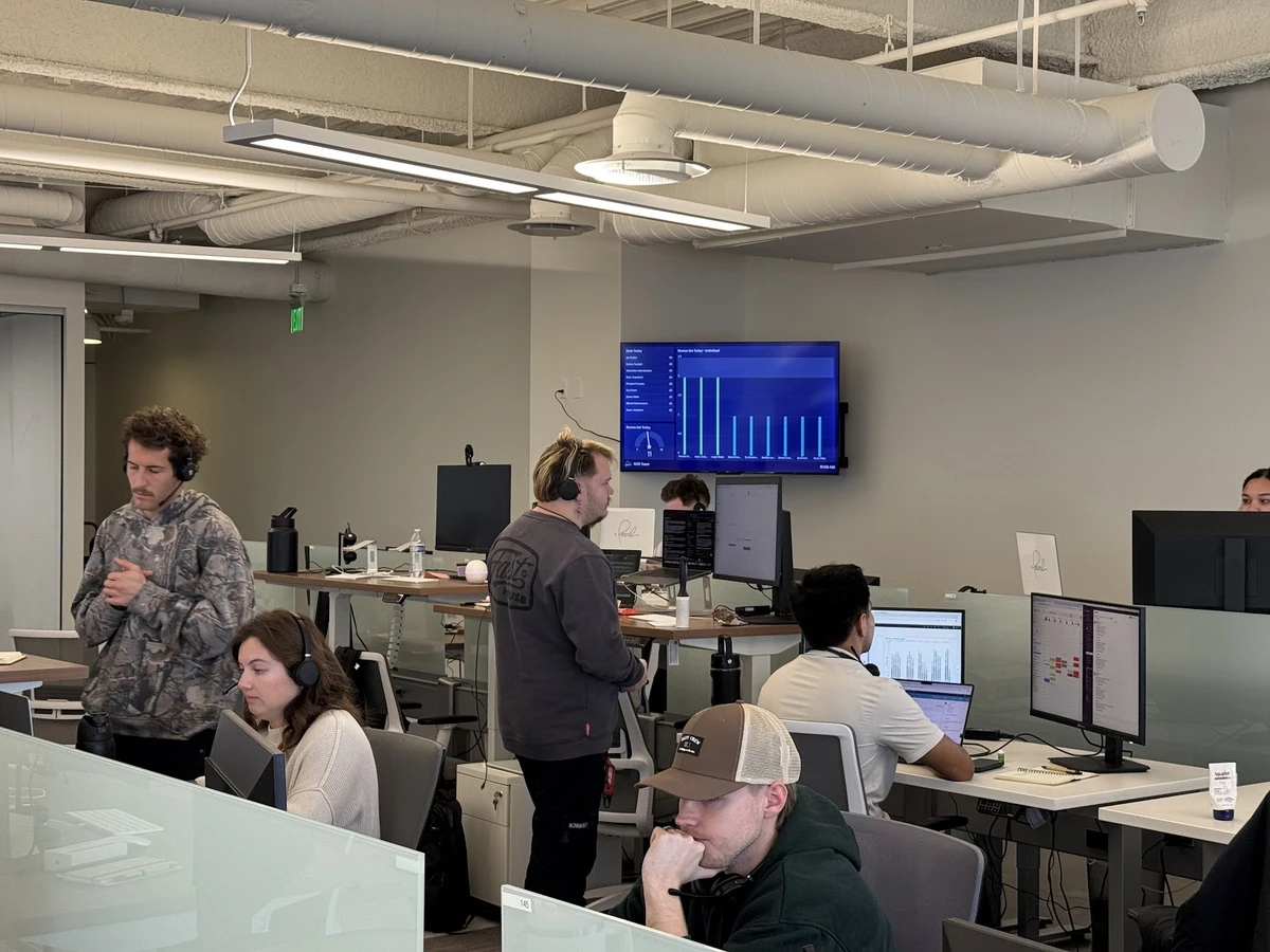 Pearl’s SDR team working in the office with their Geckoboard dashboard on the TV behind them